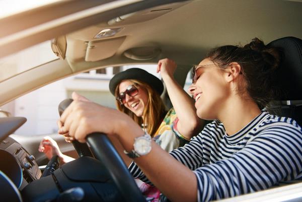 На фото – две девушки громко слушают музыку в автомобиле